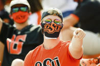 A masked Oklahoma State fan reacts during the first half of an NCAA college football game against Tulsa, Saturday, Sept. 19, 2020, in Stillwater, Okla. (AP Photo/Brody Schmidt)