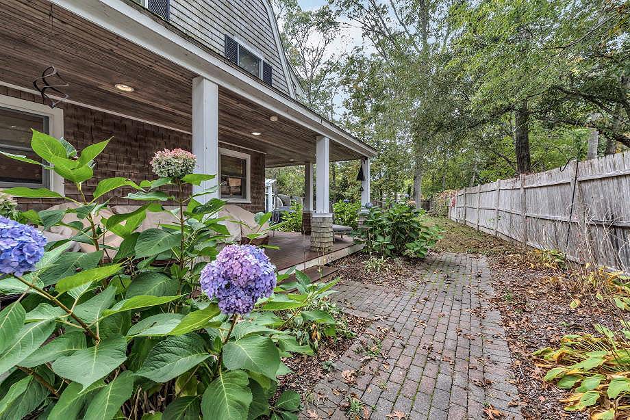 This East Falmouth home features a wraparound porch, a stunning interior open design and a "she shed" in the yard.