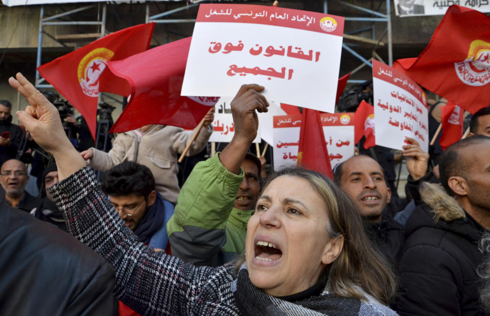Members of the Tunisian General Labor Union (UGTT) take part in a protest against president Kais Saied policies, in Tunis, Tunisia, Saturday, March 4, 2023. Banner in Arabic reads "Rule of law is above everyone". (AP Photo/Hassene Dridi)