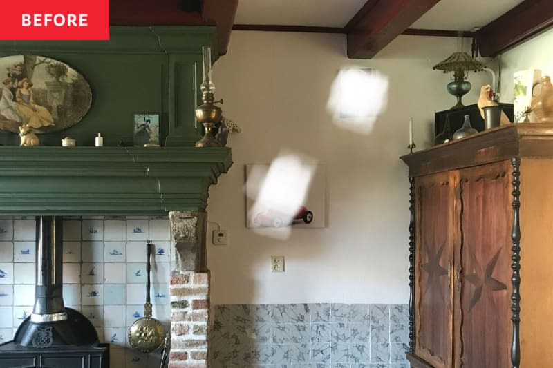 Corner of a kitchen with a fire place and large dresser.