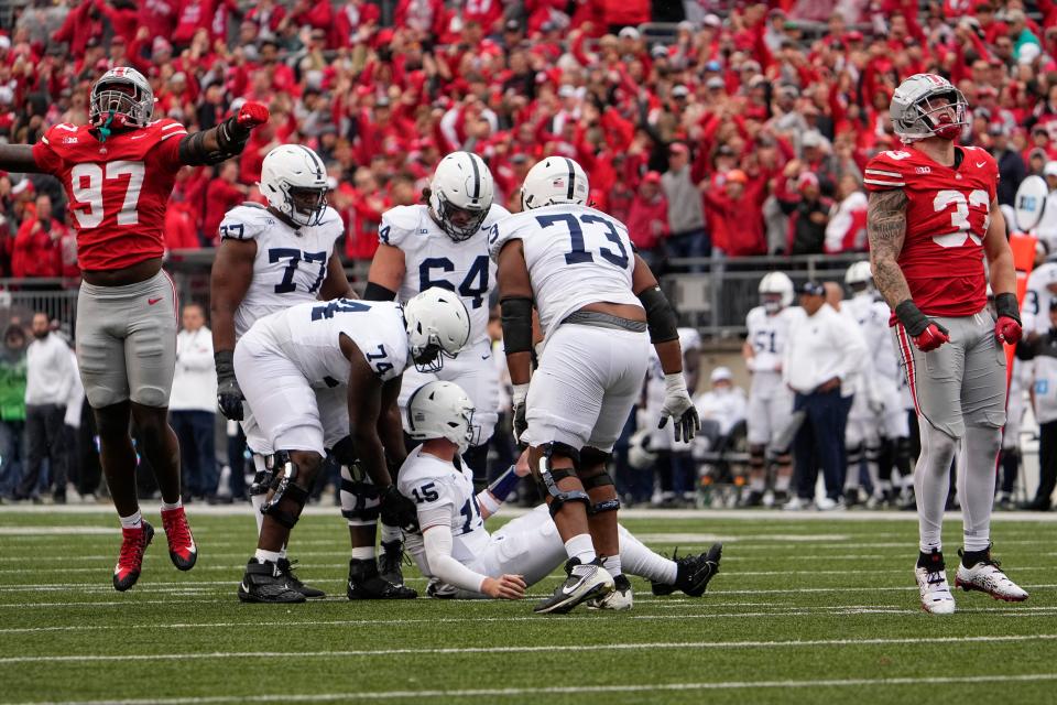 Penn State teammates help up quarterback Drew Allar (15) during the second half of their game against Ohio State at Ohio Stadium.