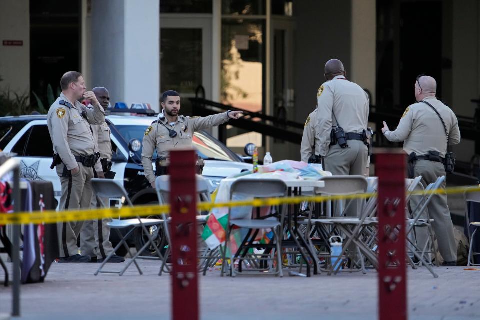 Las Vegas police stand near the scene of a shooting at the University of Nevada, Las Vegas, Thursday, Dec. 7, 2023, in Las Vegas. Terrified students and professors cowered in classrooms and dorms as a gunman roamed the floors of a campus building.