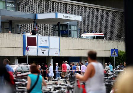 People return to the university clinic in Steglitz, a southwestern district of Berlin, July 26, 2016 after a doctor had been shot at and the gunman had killed himself. REUTERS/Hannibal Hanschke