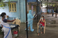 A woman gets her nasal swab sample taken to test for the coronavirus at a government health center in Hyderabad, India, Wednesday, July 15, 2020. As India’s coronavirus caseload approaches 1 million, lockdowns are being reimposed in parts of the country as governments try to shield the health system from being overwhelmed. (AP Photo/Mahesh Kumar A.)