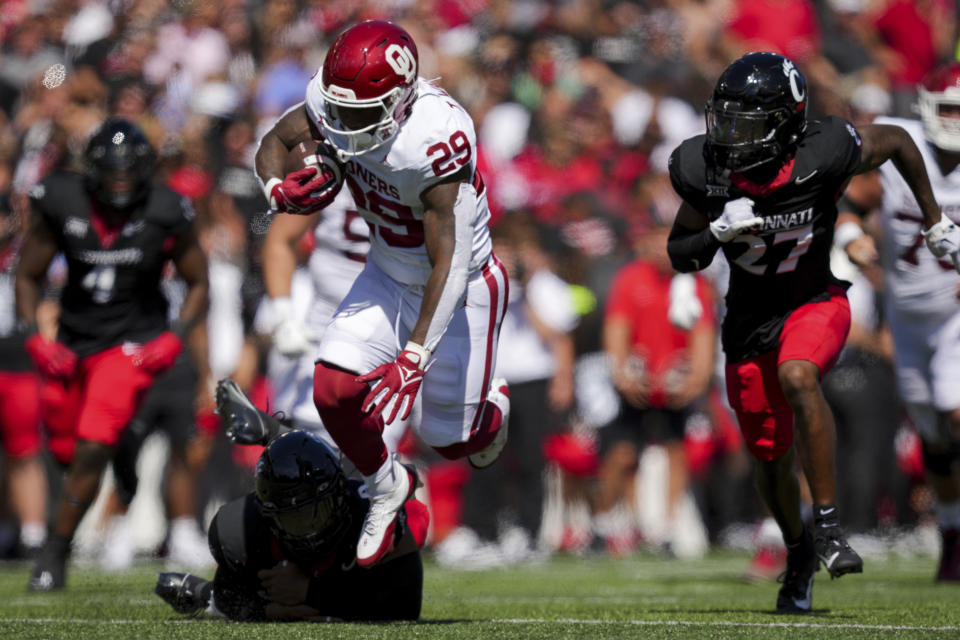 Oklahoma running back Tawee Walker (29) carries the ball as he breaks a tackle against Cincinnati linebacker Dorian Jones (6) during the first half of an NCAA college football game, Saturday, Sept. 16, 2023, in Cincinnati. (AP Photo/Aaron Doster)