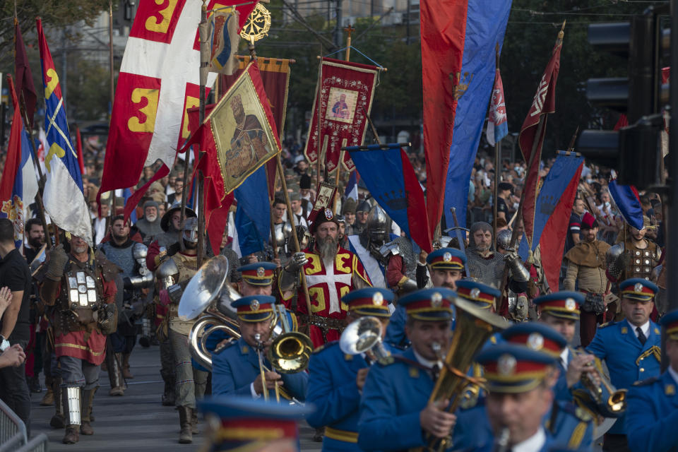 Actors portraying knights from various historic periods march together with the Serbian army honor guards during a ceremony to mark the newly established "Day of Serb Unity, Freedom and the National Flag" state holiday in Belgrade, Serbia, Wednesday, Sept. 15, 2021. Serbia has kicked off a new holiday celebrating national unity with a display of military power, triggering unease among its neighbors. (AP Photo/Marko Drobnjakovic)