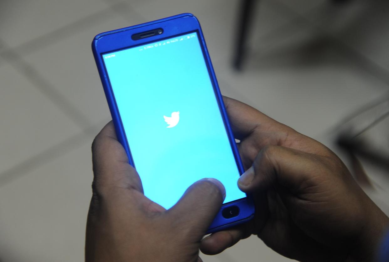 An Indian man poses for a photograph using Twitter on his cellpohne in Siliguri on March 27, 2018.  (AFP via Getty Images)