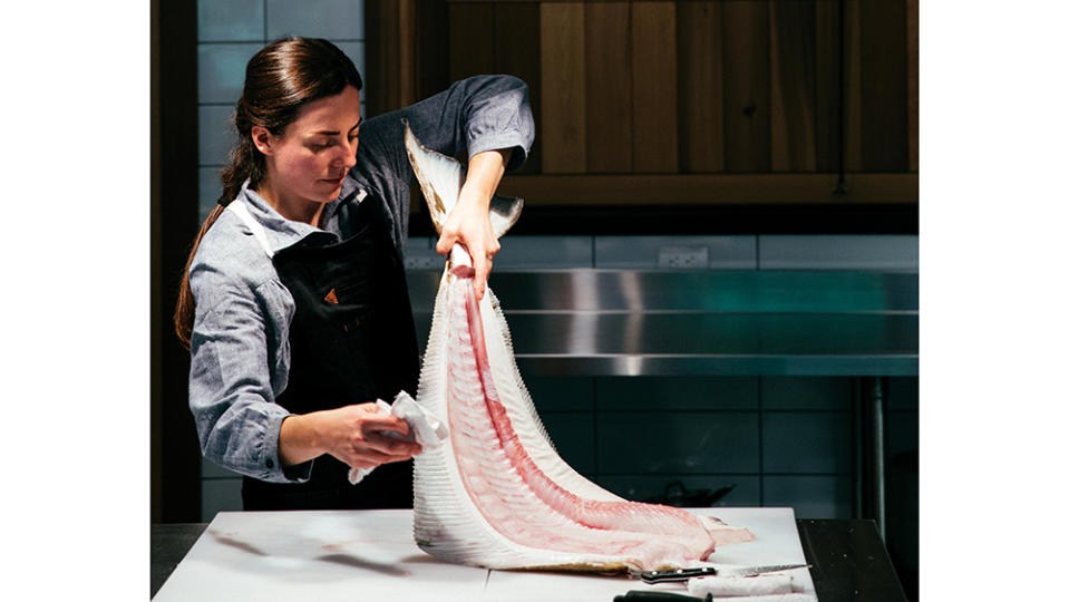 Head chef Linnéa LeTourneau trims a freshly caught halibut in the kitchen at Little River. - Credit: Jeremy Kopeks