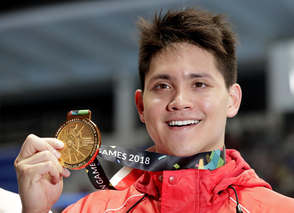 Singapore’s Joseph Schooling holds up his gold medal after winning the men’s 100m butterfly final at the 18th Asian Games in Jakarta in August. (Photo: AP/Lee Jin-man)