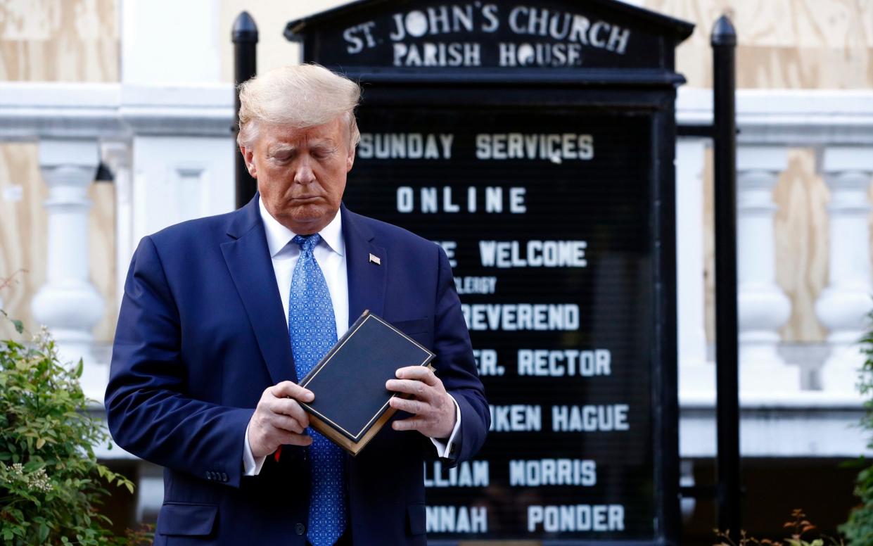 President Donald Trump holds a Bible as he stands outside St John's Church across Lafayette Park from the White House