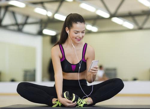 Woman in exercise clothes looking at an iPhone