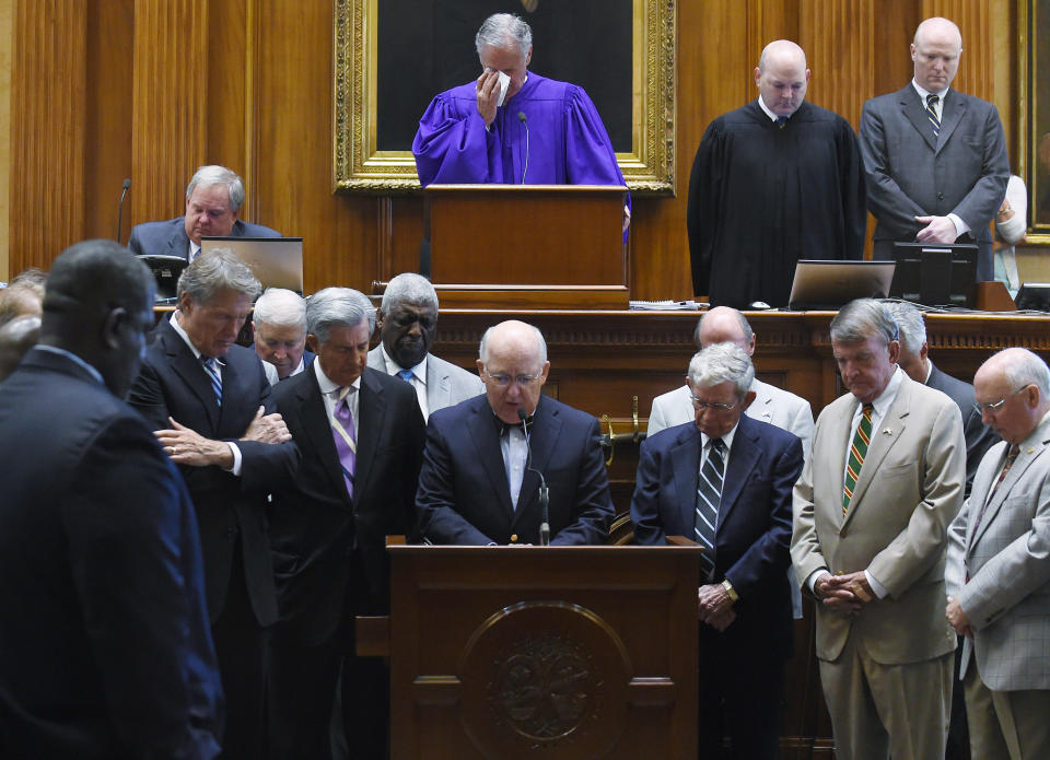 Chaplain James St. John, center, leads senators in prayer, Thursday, June 18, 2015, at the Statehouse in Columbia, S.C.  State Sen. Clementa Pinckney was one of those killed Wednesday night in a shooting at the Emanuel AME Church in Charleston.  (AP Photo/Rainier Ehrhardt)