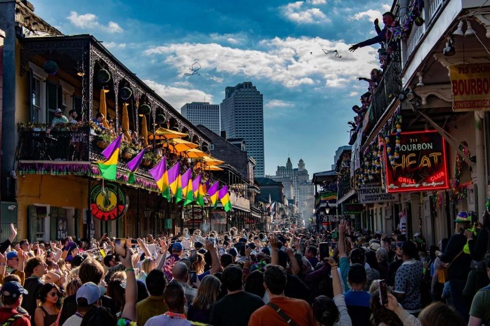 Crowds gather and beads fly on New Orleans’ Bourbon Street ahead of a walking parade in the French Quarter.