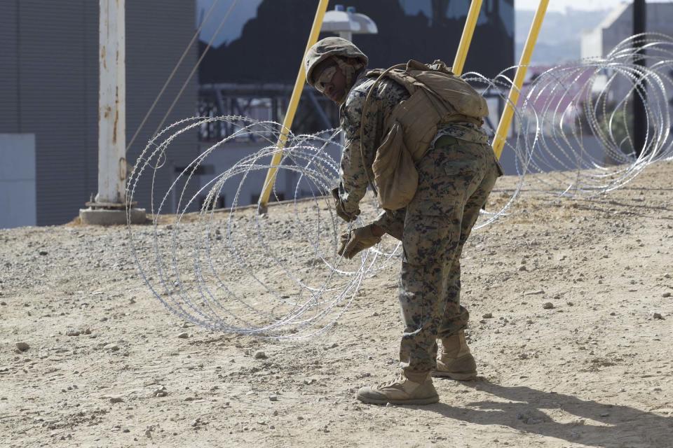 In a Nov. 6, 2018 photo, Marine Corps engineers from Camp Pendleton put up razor wire just east of the San Ysidro Port of Entry where trains pass from the US in to Mexico and Mexico to the US to support Border Patrol after President Trump has said he fears an invasion of Hondurans arriving in coming weeks. (John Gibbins/The San Diego Union-Tribune via AP)