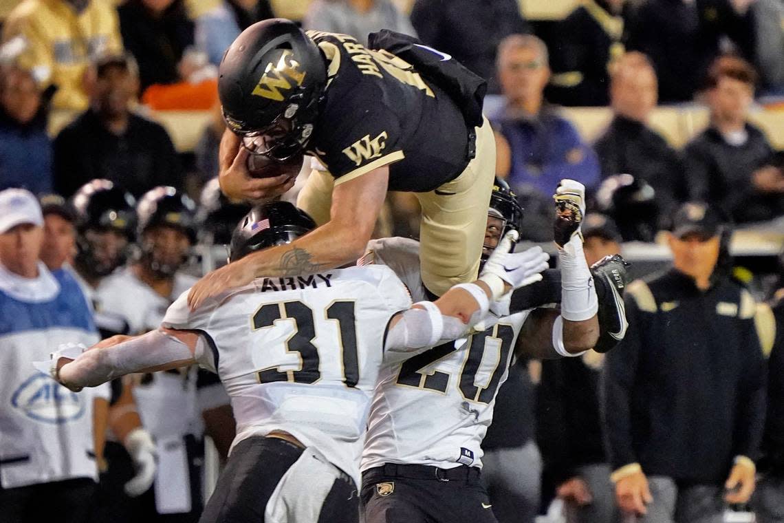 Wake Forest’s Sam Hartman (10) tries to leap over Army’s Leo Lowin (31) during the second half of an NCAA college football game in Winston-Salem, N.C., Saturday, Oct. 8, 2022. (AP Photo/Chuck Burton)