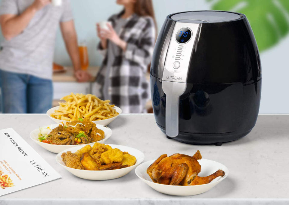 The Ultrean Air Fryer on a table next to air-fried foods