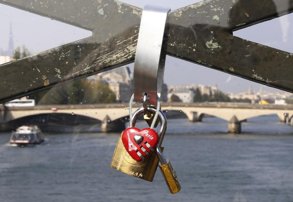 Padlocks are seen through a plastic panel which protects the fence of the Pont des Arts over the River Seine in Paris September 23, 2014. (REUTERS/Jacky Naegelen)