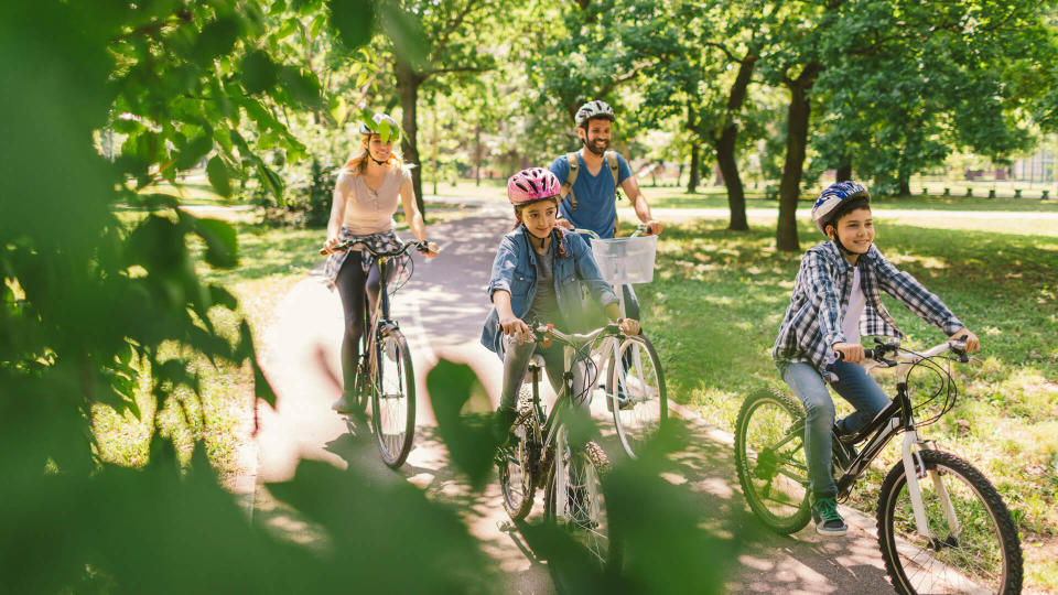 Family riding bicycle in the public park together.