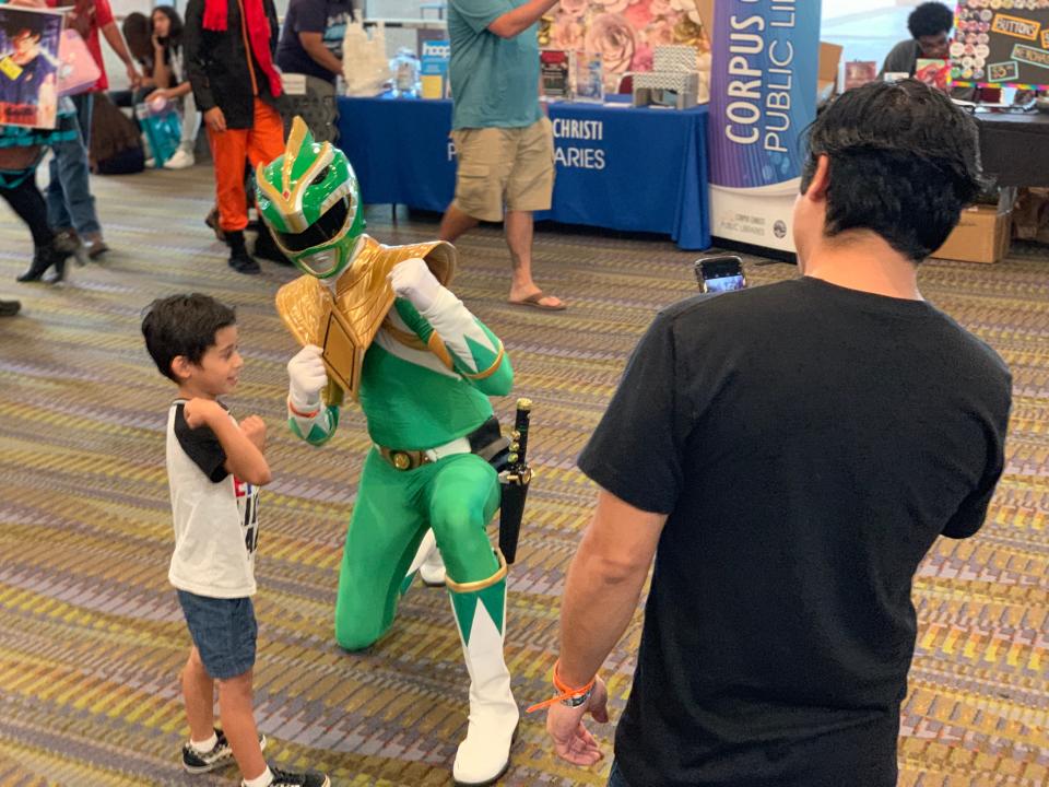 A little boy poses with a cosplayer dressed up as the green Power Ranger at the third annual Corpus Christi Comic Con on Saturday, June 29, 2019.