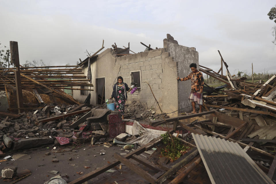 Villagers inspect the damage at their home in an area affected by the eruption of Mount Semeru in Lumajang, East Java, Indonesia, Sunday, Dec. 5, 2021. The highest volcano on Indonesia’s most densely populated island of Java spewed thick columns of ash, searing gas and lava down its slopes in a sudden eruption triggered by heavy rains on Saturday. (AP Photo/Trisnadi)