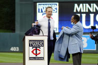 Former Minnesota Twins player Justin Morneau, left, sheds his jacket as former Twins great and Hall of Famer Rod Carew presents the new jacket after Morneau was inducted into the Twins' Hall of Fame prior to a baseball game against the Toronto Blue Jays, Saturday, Sept. 25, 2021, in Minneapolis. (AP Photo/Jim Mone)