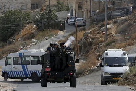 An Israeli paramilitary police officer fires a tear gas canister towards Palestinian stone-throwers in Jabel Mukaber, in an area of the West Bank that Israel captured in a 1967 war and annexed to the city of Jerusalem, October 12, 2015. REUTERS/Ammar Awad