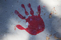 A red handprint is painted along a walkway which leads from the Bountiful High School parking lot up to the football field Tuesday, July 28, 2020, in Bountiful, Utah. While advocates have made strides in getting Native American symbols and names changed in sports, they say there's still work to do mainly at the high school level, where mascots like Braves, Indians, Warriors, Chiefs and Redskins persist. (AP Photo/Rick Bowmer)