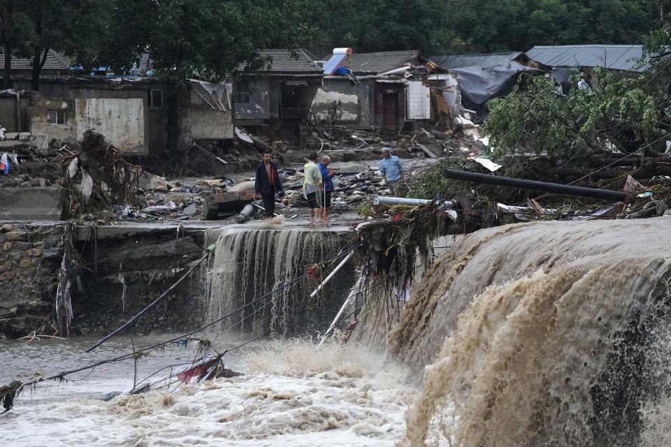 2023年7月31日，北京，連續降雨引發警報，村民聚集在被洪水破壞的村莊附近。攝：Andy Wong/AP/達志影像