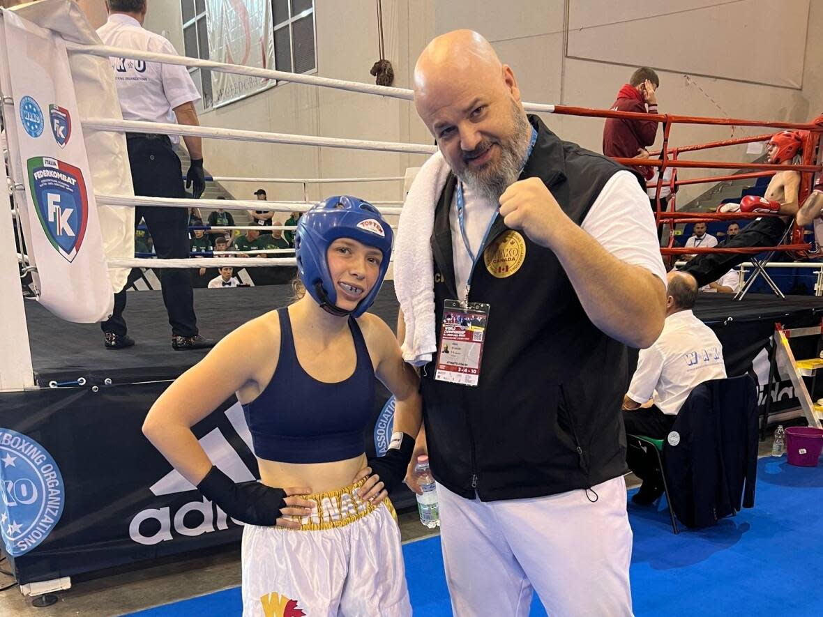 Anna Snow, left, was a silver medallist at the world kickboxing championships in Venice, Italy. She stands next to her coach John Stanley, co-owner and coach of Stanley Boxing and Fitness. (Submitted by John Stanley - image credit)