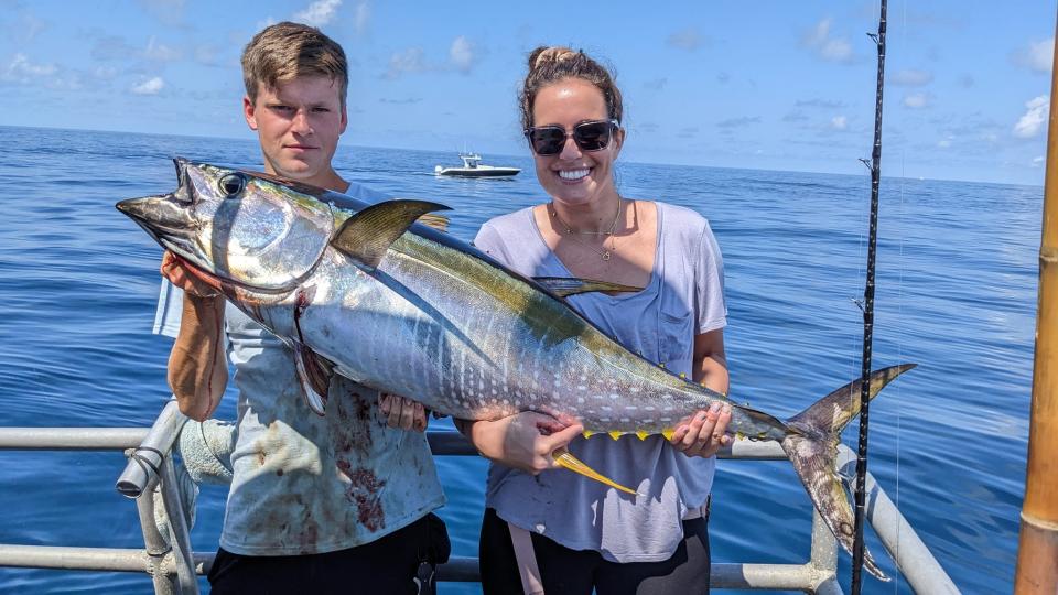 Brad Redler, left, and Nicole Bogan, right, with one of several yellowfin tuna landed on the Big Jamaica party boat on Tuesday.