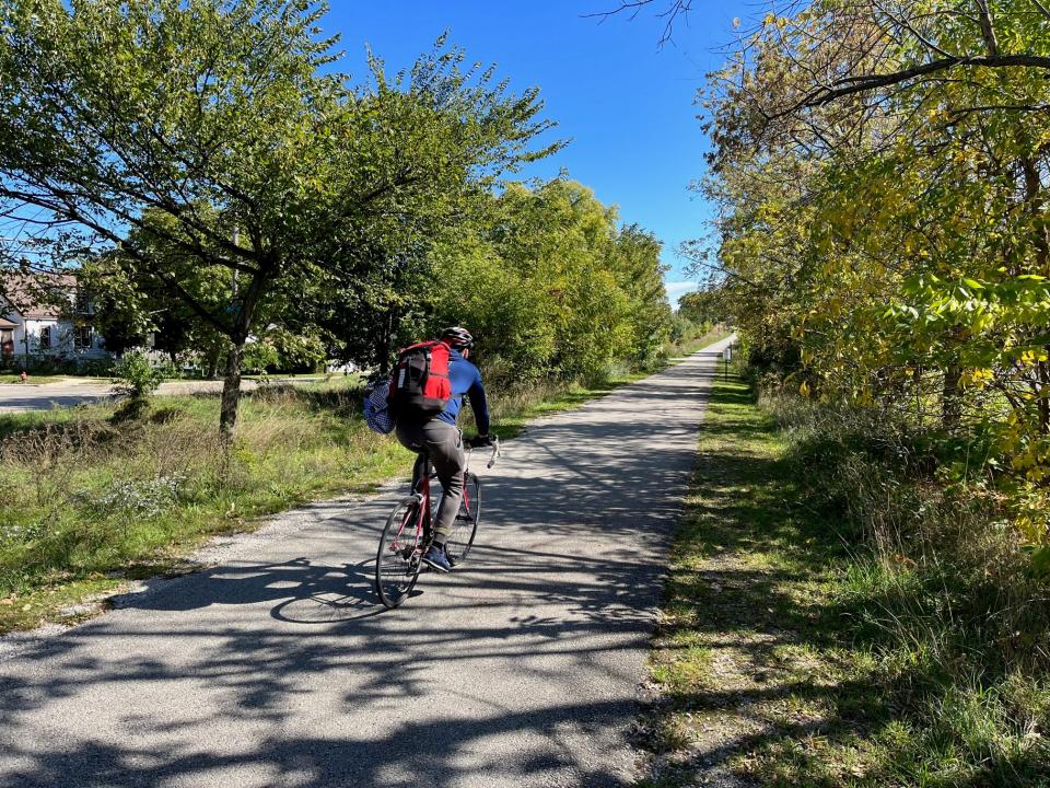 A cyclist rides along the Hank Aaron State Trail at the southern edge of the Johnson's Woods neighborhood in Milwaukee.