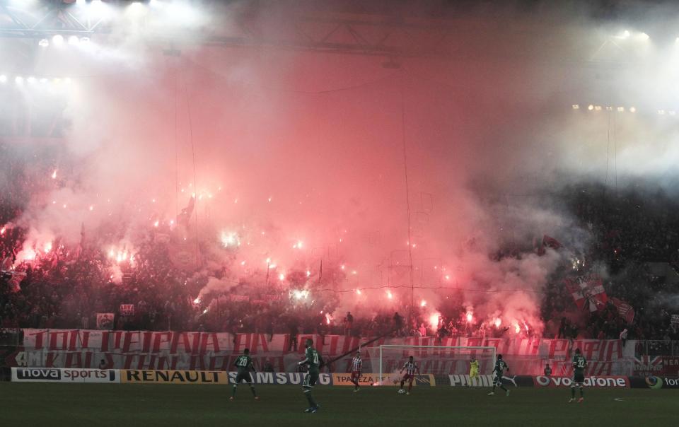 Olympiakos' fans hold flares during a Greek League soccer match against Panathinaikos at Georgios Karaiskakis stadium, in Piraeus port, near Athens, on Sunday, March 2, 2014. (AP Photo/Thanassis Stavrakis)