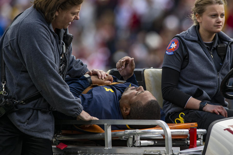 Michigan running game coordinator Mike Hart was carted off the field on a backboard during the first half of an NCAA college football game against Indiana, Saturday, Oct. 8, 2022, in Bloomington, Ind. (AP Photo/Doug McSchooler)