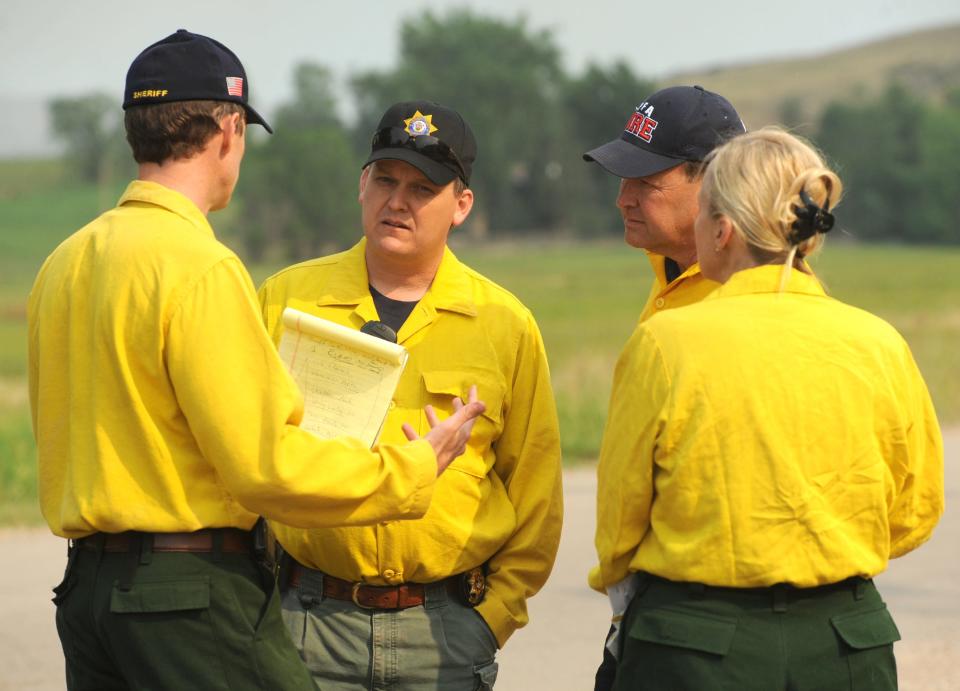 Larimer County Sheriff Justin Smith, center, talks with others before a media briefing on the High Park Fire on June 10, 2012, at the Watson Lake State Wildlife Area in Bellvue.