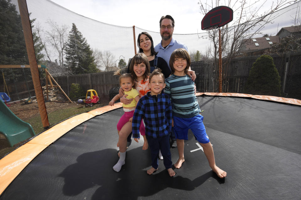 Christina and Roy Taylor pose with their children Magdalena, River, Titus and Ofelia in the family's backyard in Littleton, Colo., on Sunday, March 27, 2022. Taylor chose to get an abortion when she found out after 20 weeks that her baby had no kidneys or bladder. Taylor said she honors her loss with the casts, which were made by the hospital's bereavement team. (AP Photo/David Zalubowski)