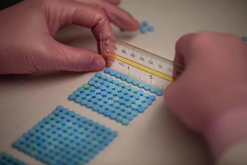 Laura Kimble, senior drug chemist and forensic scientist with the Hamilton County CoronerÕs Crime Laboratory located in Blue Ash, counts out fake oxycodone in the Blue Ash-based lab in 2022.