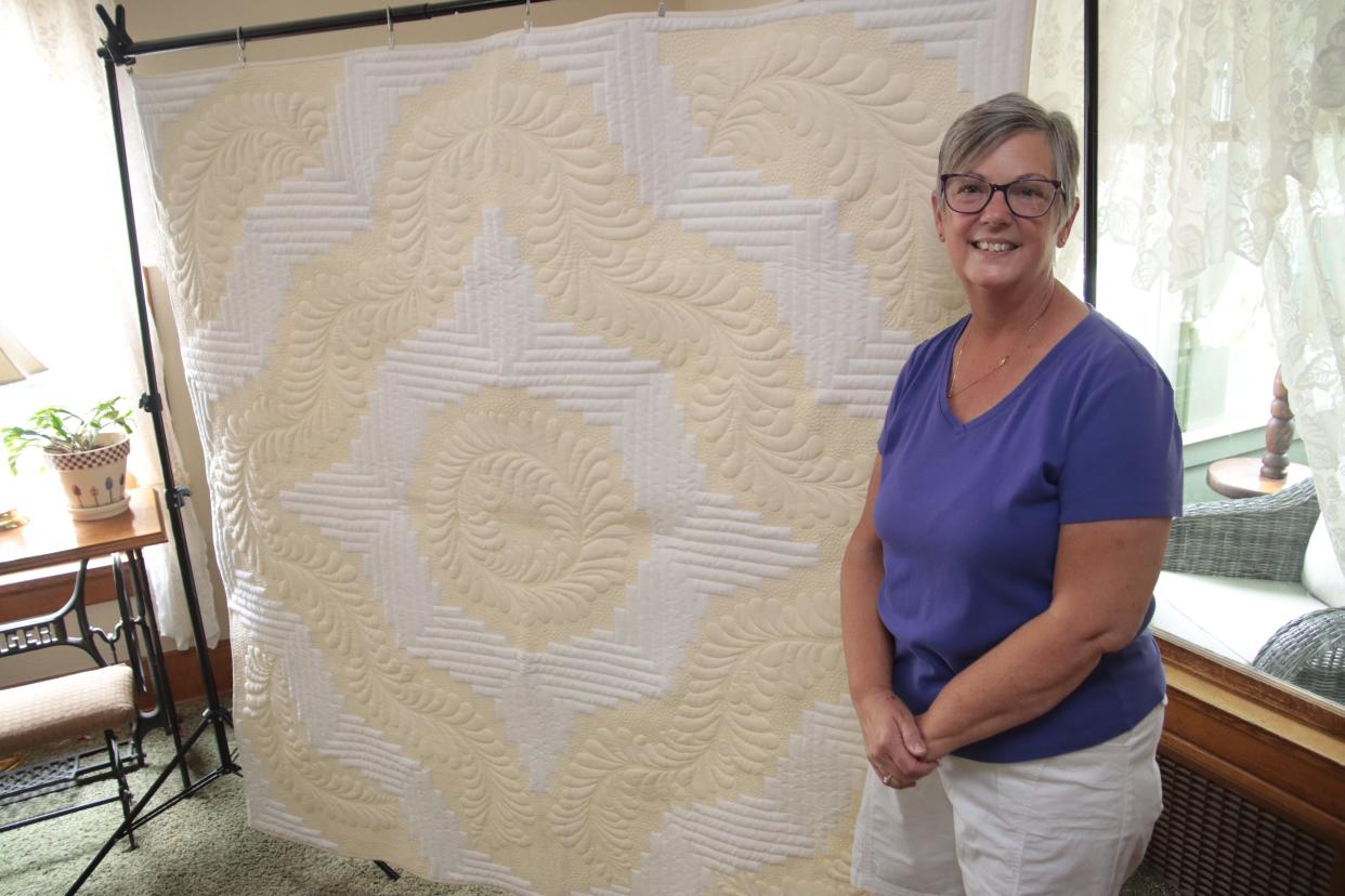 Connie Stover is pictured Friday at her home in Morenci with her quilt, "Fancy Feathers and Champagne Bubbles," that she will take as a semifinalist to the 2022 American Quilters Society QuiltWeek in Grand Rapids. The show is Aug. 17-20.