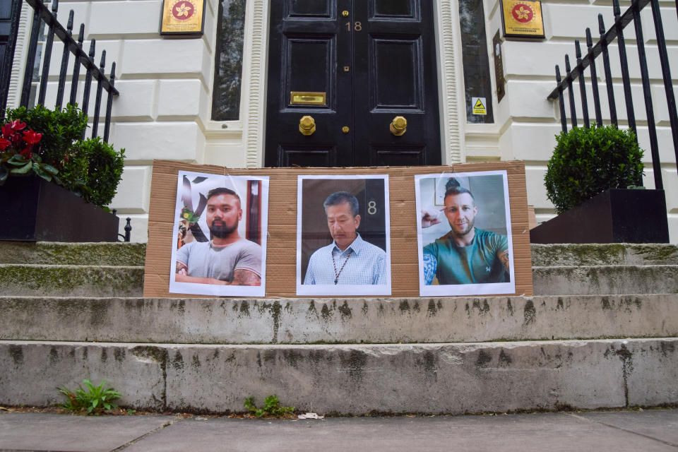 倫敦經貿辦爆出間諜案醜聞後，辦事處外被示威者張貼三名被告的照片，左起是衞志樑、袁松彪、Matthew Trickett。 (Photo by Vuk Valcic/SOPA Images/LightRocket via Getty Images)