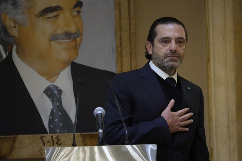 Former Lebanese Prime Minister Saad Hariri, gestures in front of a picture of his late father and former Prime Minister of Lebanon Rafic Hariri, after he gave a speech at his house in downtown Beirut, Lebanon, Monday, Jan. 24, 2022. Hariri said Monday he is suspending his work in politics and will not run in May's parliamentary elections. (AP Photo/Hussein Malla)