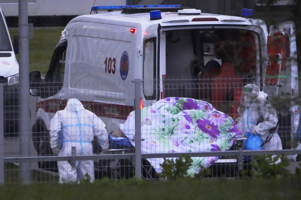 Medical workers carry a patient suspected of having coronavirus on a stretcher at a hospital in Kommunarka, outside Moscow, Russia, Saturday, Oct. 16, 2021. Russia's daily death toll from COVID-19 has exceeded 1000 for the first time as the country faces a sustained wave of rising infections. (AP Photo/Alexander Zemlianichenko)