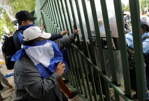 Students, friends and relatives of political prisoners protest in front of a police line at the Central American University in Managua on November 19