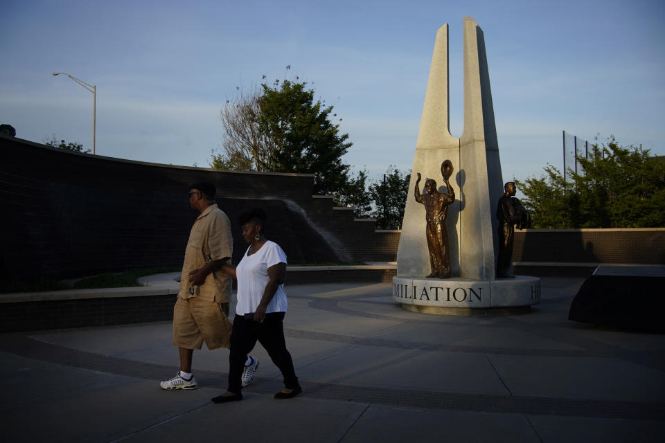 Demetrius Boyd, left, and Loretta Boyd walk by a sculpture recognizing the Tulsa Race Massacre at the John Hope Franklin Reconciliation Park, Wednesday, May 26, 2021, in Tulsa, Okla. The two, from Tulsa, visited the park memorializing the Tulsa Race Massacre ahead of the 100 year anniversary. "History and education, and you have a sense of calmness and peace," said Demetrius Boyd about visiting the park for the first time. (AP Photo/John Locher)