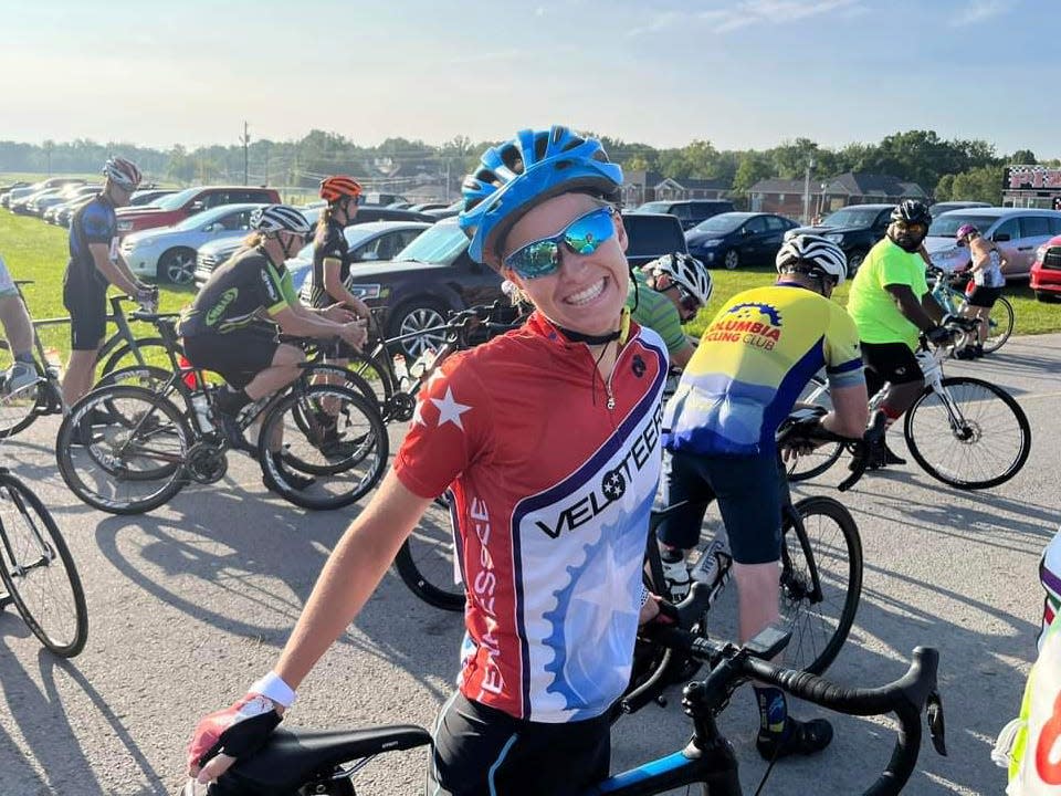 A photo of Alyssa Mulligan at a cycling event wearing a helmet and sunglasses