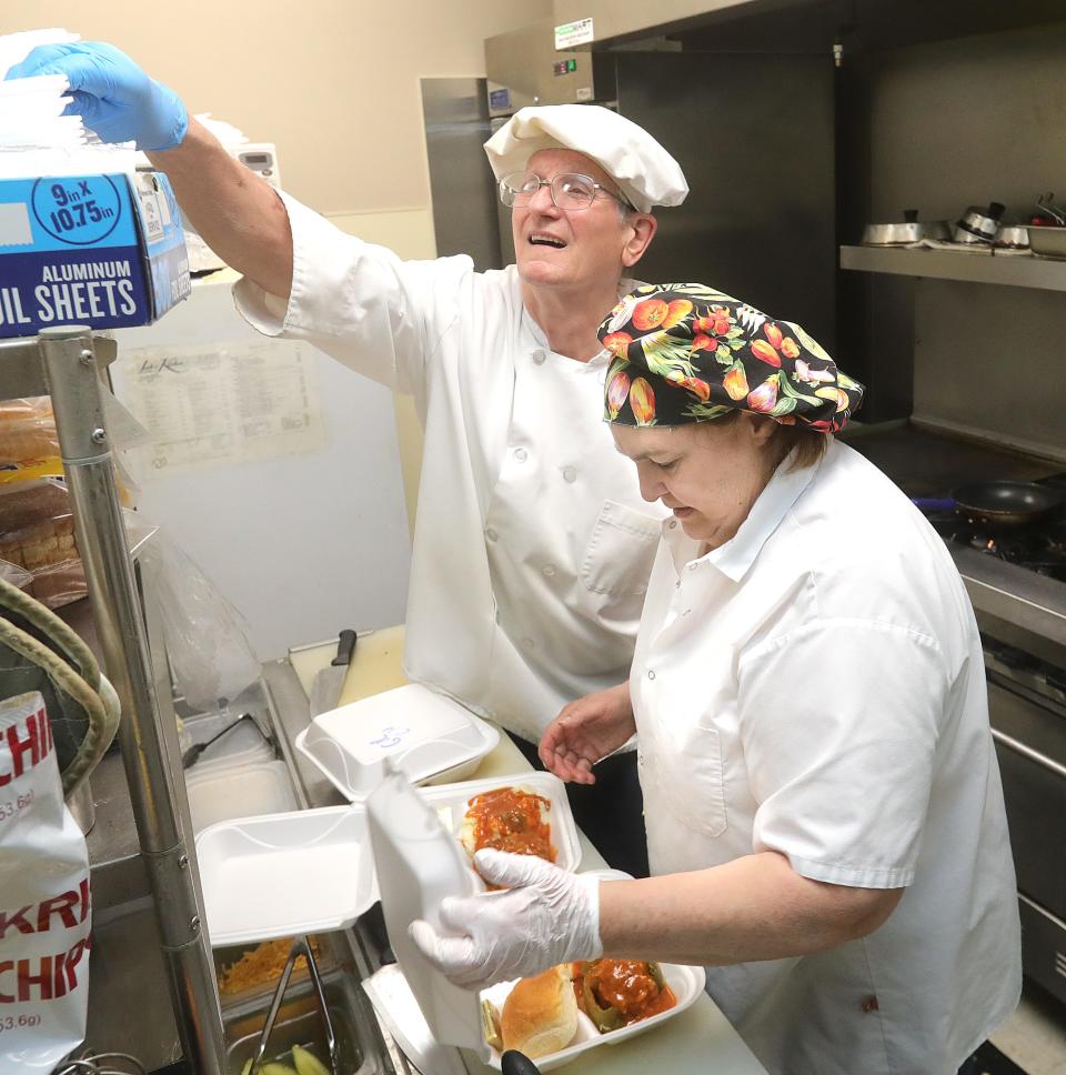 Randy and Leah Francis prepare orders of the stuffed pepper lunch special for customers on Wednesday April 27, 2022 in Akron. The couple is calling it quits after running LeahÕs Kitchen for 18 years inside the Summit County Public Health Building.