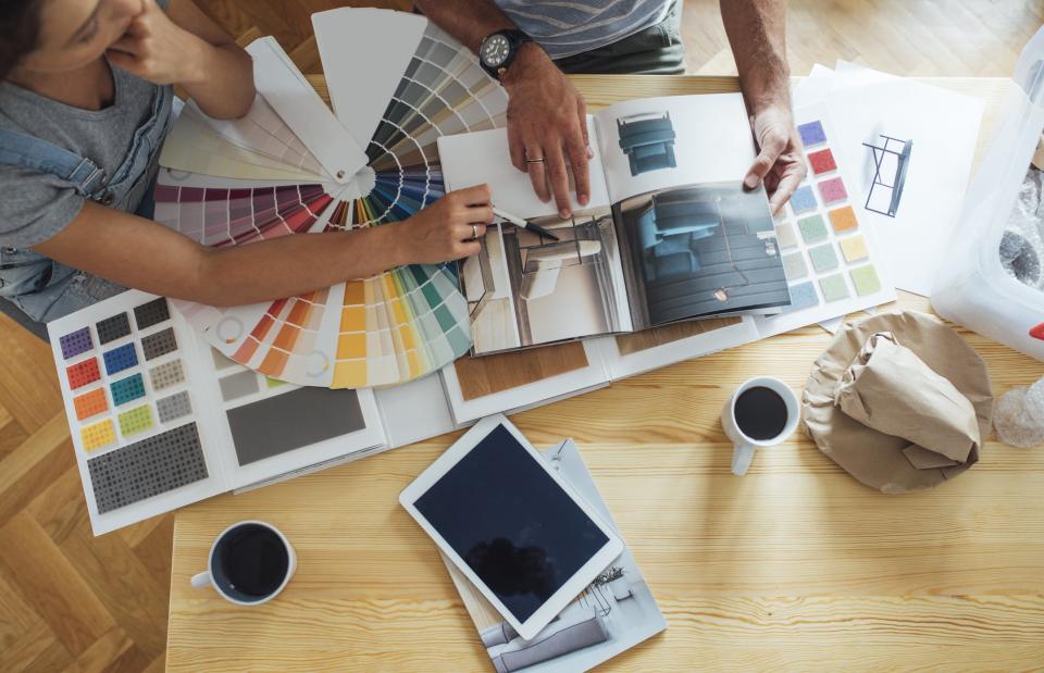 A couple looks through home decor magazines and samples.