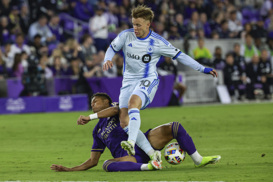 Orlando City defender Rafael Santos, bottom, takes the ball away from CF Montréal midfielder Bryce Duke (10) during the first half of an MLS soccer match Saturday, Feb. 24, 2024, in Orlando, Fla. (AP Photo/Kevin Kolczynski)