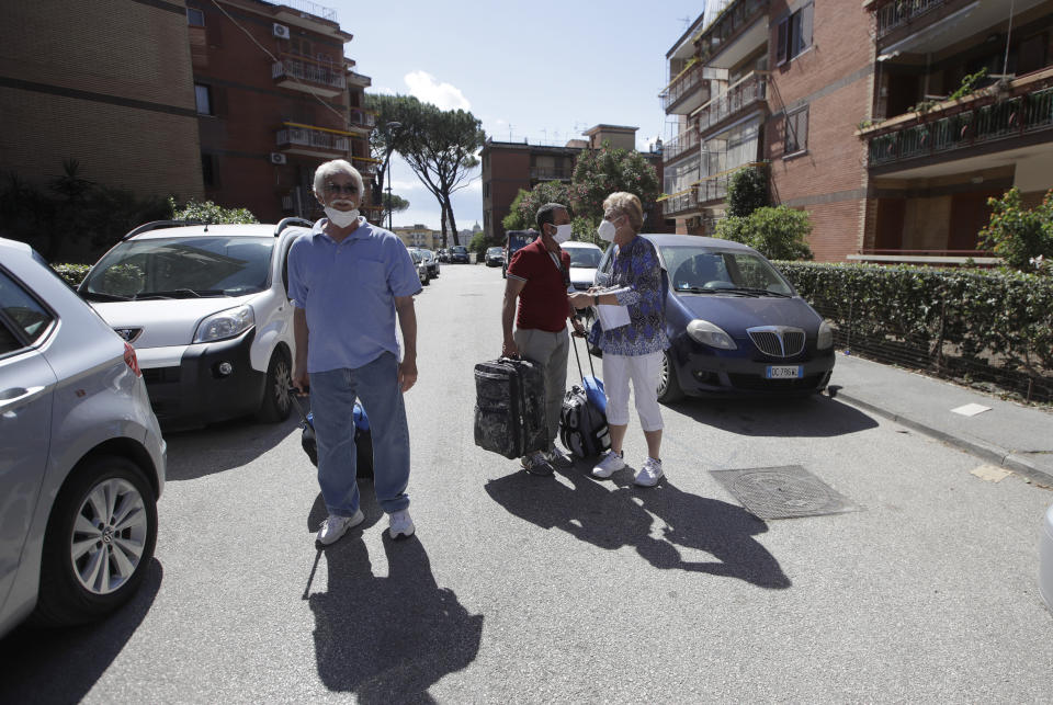 Marvin and Colleen Hewson, from the United States, accompanied by owner Fabio Sposato leave the apartment where they stayed in Pompeii, near Naples, southern Italy, Tuesday, May 26, 2020. An American couple waited a lifetime plus 2 ½ months to visit the ancient ruins of Pompeii together. For Colleen and Marvin Hewson, the visit to the ruins of an ancient city destroyed in A.D. 79 by a volcanic eruption was meant to be the highlight a trip to celebrate his 75th birthday and their 30th anniversary. They were among the only tourists present when the archaeological site reopened to the public on Tuesday after the national lockdown to prevent the spread of COVID-19. (AP Photo/Alessandra Tarantino)