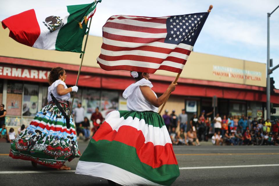 Performers carry the Mexican and U.S. flags in a parade in Santa Ana, California, in September 2019.
