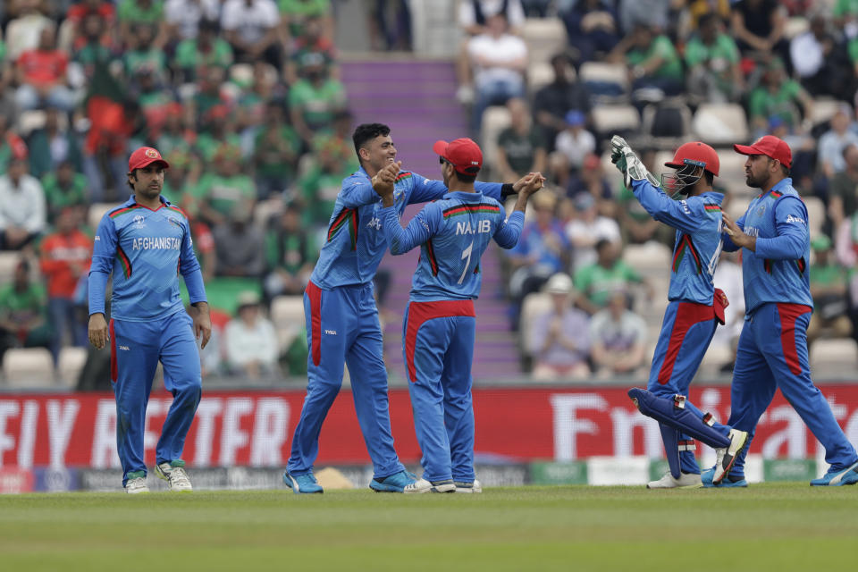 Afghanistan's Mujeeb Ur Rahman, second left, celebrates taking the wicket of Bangladesh's Shakib Al Hasan during the Cricket World Cup match between Bangladesh and Afghanistan at the Hampshire Bowl in Southampton, England, Monday, June 24, 2019. (AP Photo/Matt Dunham)