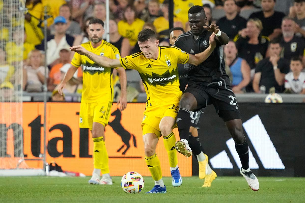 Jul 3, 2024; Columbus, OH, USA; Columbus Crew midfielder Sean Zawadzki (25) fights for the ball with Nashville SC forward Forster Ajago (21) during the first half of the MLS soccer game at Lower.com Field.